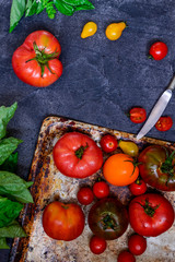 Top view colorful tomatoes, red tomatoes, yellow tomatoes, orange tomatoes with water drops on the dark concrete background. Space for text, selective focus