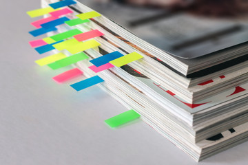 many colorful bookmarks in a magazine with the shallow depth of scene - obrazy, fototapety, plakaty