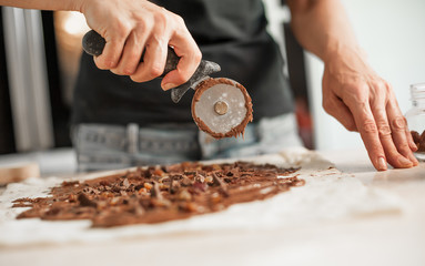 Professional confectioner making tasty cake with melted chocolate