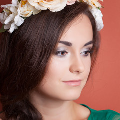 beautiful young woman wearing wreath against red background