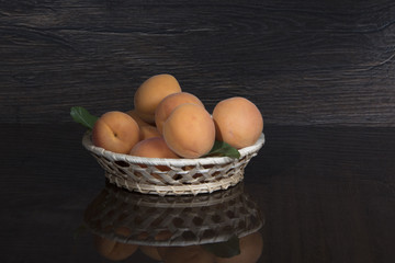 Apricots in bowl on a dark background