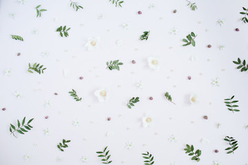 Floral pattern with flower buds, green leaves, branches. Flat lay, top view background.