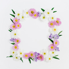 Fototapeta na wymiar Floral frame of white and pink chamomile daisy flowers, green leaves on white background. Flat lay, top view. Daisy background. Mock up frame of flower buds.