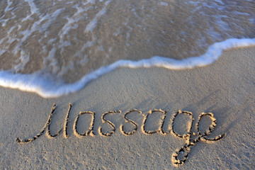Massage concept written on sand.