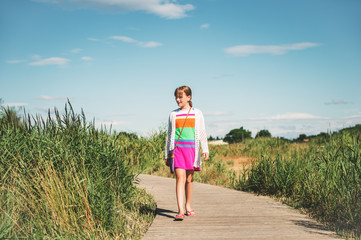 Kid girl tourist enjoying promenade in Camargue, marais du Vigueirat, swamps, pathway in natural reserve