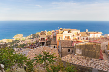 Panoramic view of small Village of Castelmola, overlooking town of Taormina with sea background, Sicily island, Italy