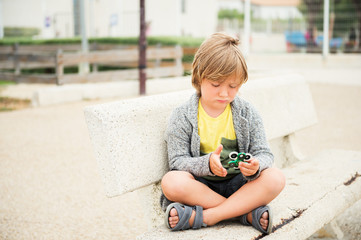 Very sad kid playing with fidget hand spinners © annanahabed