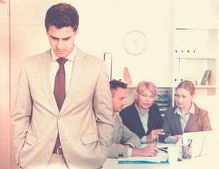 Business team solving problems with upset man foreground