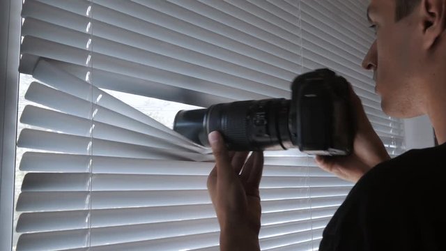 4K Spy, paparazzi or detective shooting on camera through the window blinds
