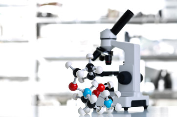 Microscope with molecule model in lab