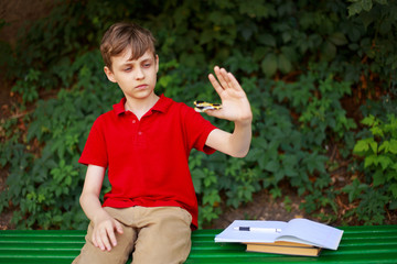 Gadget addiction. Schoolboy playing with fidget spinner instead of classes. Education, childhood,...