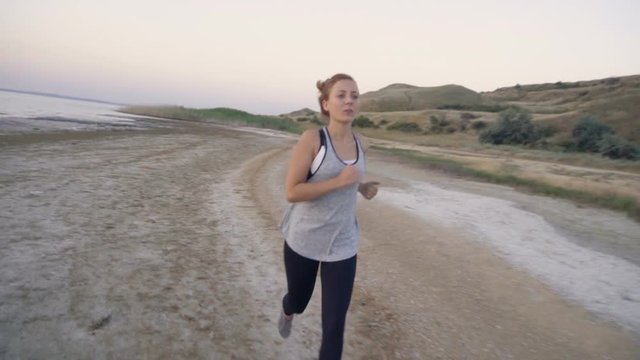Woman jogs at sunrise, early morning exercise on the shore
