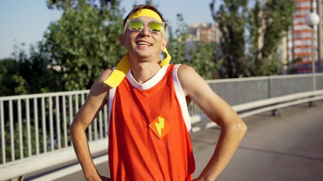 Funny thin man freak is happy after training in the city park.