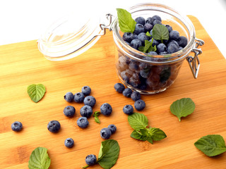 Blueberries in a glass jar on a wooden board
