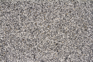 Wall of small stones texture. Pebbles and sand wall texture. Small stones wall background for design with copy space for text or image.