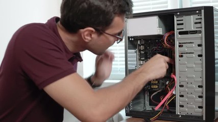 Closeup view of a concentrated computer service worker in glasses fixing a broken computer in the office and upgrading computer hardware. Support team. Computer maintenance. Shot in 4k