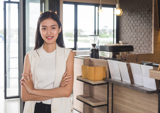 Young Asian Woman Business Owner At Front Of Cafe/bar/restaurant/coffee And Bakery Shop