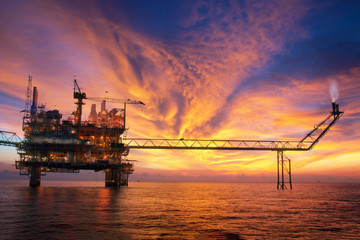 silhouette of an oil and gas offshore platform during sunset time - Powered by Adobe