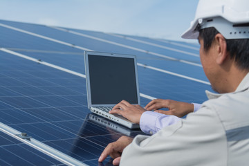 engineer working on checking and maintenance electrical equipment ; engineer inspector working on examining electrical system of solar power plant 
