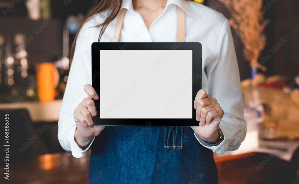 Poster Close up on blank tablet computer that barista show and holding with two hand in front of coffee shop counter bar,Mock up space for display of menu or design