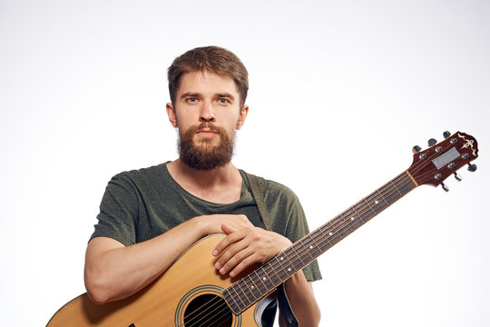 Man with a beard holding a guitar on a white isolated background, musical instruments, music