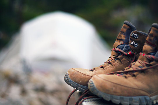 Hiking boots in focus with tent