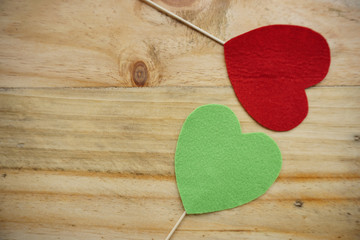 Top or flat lay view of Photo booth props a green heart and a red heart on a wooden background flat lay. Birthday parties and weddings.