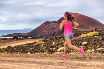 Trail runner athlete woman running training cardio on rocky mountain path on long distance endurance run in summer outdoors nature landscape. Female sports fitness person working out.