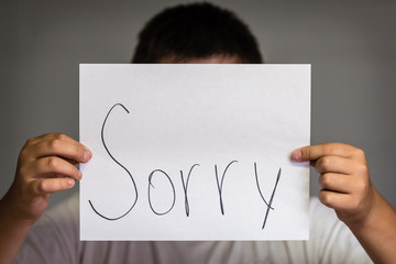 Boy Holding Up Sorry