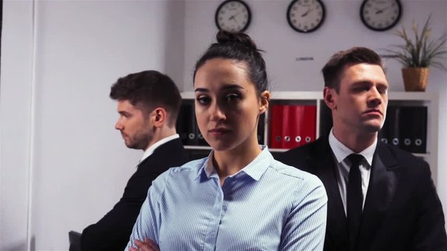 Cool Epic shot of three 3 confident collegues attractive handsome business managers businessman and businesswoman office inside turn their head to camera. Slow motion.