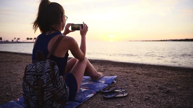 Dolly slide around person at beach take photo of sunset 4K