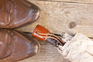 brown boots, an umbrella on wooden background