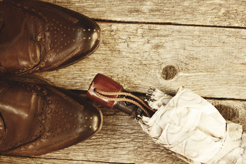 brown boots, an umbrella on wooden background