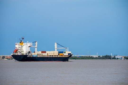 Logistics and shipping transportation of cargo ship, international import export vessel on ocean or river in evening