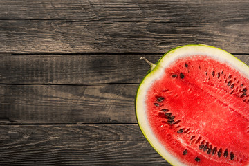 Watermelon on old wooden background, top view