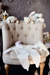 Things for the newborn baby lie on the chair. Toy bears are also waiting for the appearance of the baby..