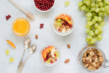 Healthy breakfast food table: granola, fruits, yogurt and honey. Table top view