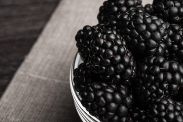 Fresh Ripe Juicy Blackberries in a plate on black background