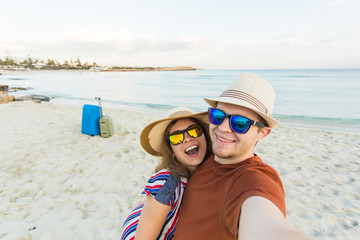 tourists couple taking selfie on the beach. Vacation, love, travel and holiday concept.