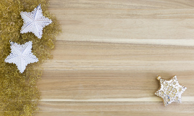 Beautiful white and gold christmas decoration stars on gold glitter and wood background.