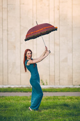 Portrait of beautiful red-haired young woman with umbrella