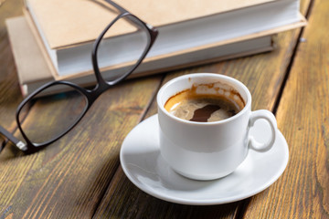 Vintage book and a cup of coffee on wooden background