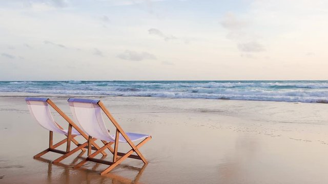 Two beach chairs on the beautiful sunset beach.
