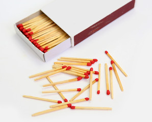 matchbox opened on white, pile match outside the box.