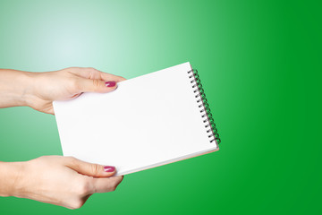 Obraz premium Woman Hand Holding Blank Spiral Notepad.