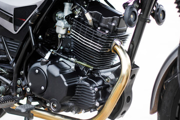 Black motorcycle engine, detail of motorcycle engine on white background.
