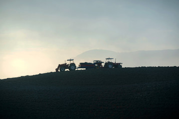 Farmer in tractor preparing land with seedbed cultivator