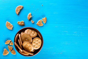 A bowl with crispy crackers on a blue background