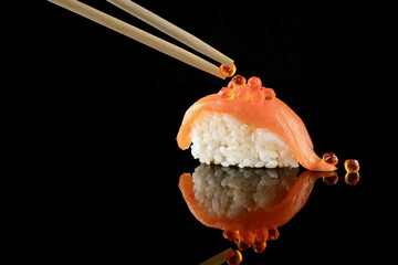Japanese Sushi whith salmon on black background and whith reflection. Organic food.