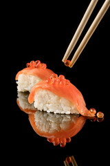 Japanese Sushi whith salmon on black background and whith reflection. Organic food.